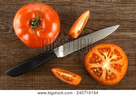 Red Tomato Composition With A Knife Isolated On Brown Wood Background Top View One Whole One Section