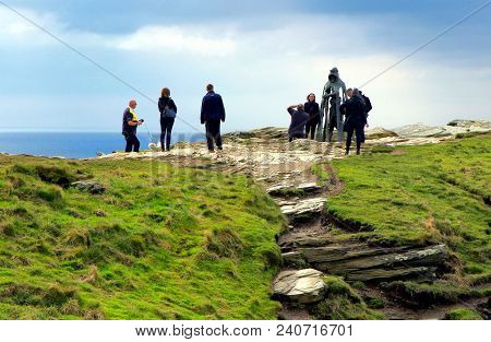 Tintagel, Cornwall, Uk - April 10 2018: Tourists Posing For Photographs At The King Arthur Statue Ga