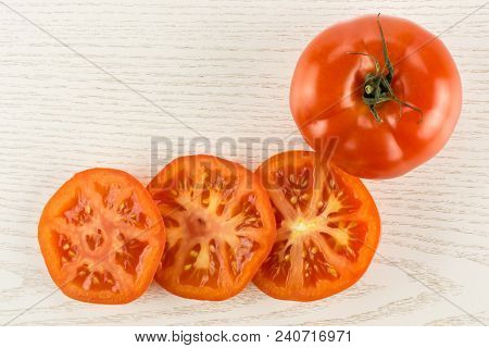 One Red Tomato And Three Slices Top View Isolated On Grey Wood Background