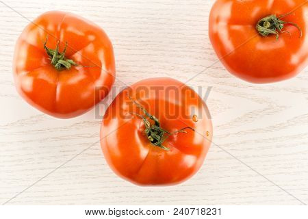 Three Red Tomato Isolated On Grey Wood Background Top View
