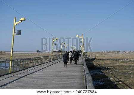 People Walking  A Cold And Clear Windy Day To The Big Beach. Sankt Peter Ording In The German Part O
