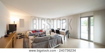 Living room with sofas, table with chairs to eat and a modern kitchen. Interior of open space apartment