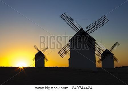 Silhouettes Of Traditional Windmills At Campo De Criptana Site, Spain. Rising Backlighing
