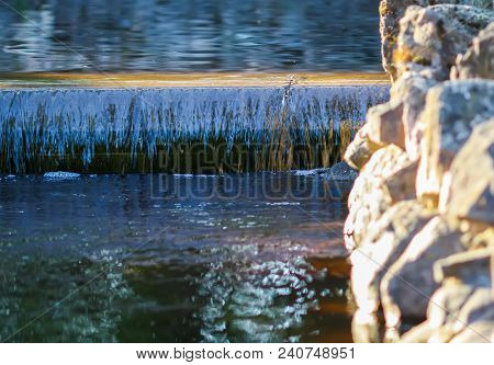 Cold Transparent Water Of Decorative Artificial Waterfall In Summer Park.