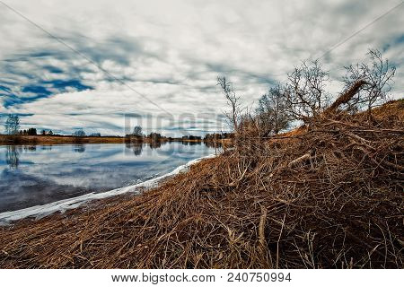 The Spring Sky Reflects Of The Water Of The River In The Northern Finland. The Flooding River Has Br