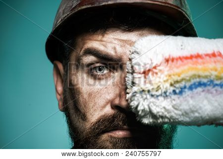 Painter With Painting Roller. Professional Painter Worker In Protective Helmet. Bearded Decorator Ho