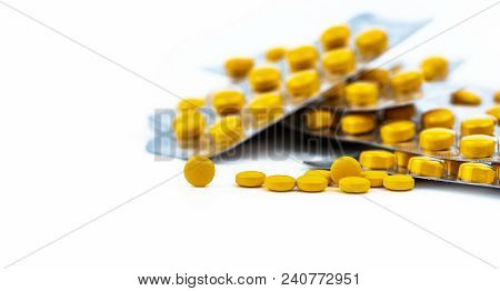 Selective Focus On Yellow Tablets Pill On Blurred Background Of Blister Pack Of Round Yellow Pills. 