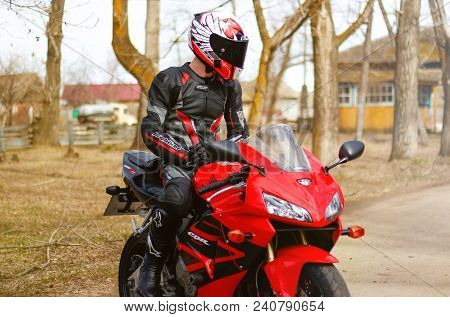 Krasnoyarsk, Russia - April 21, 2018: Beautiful Motorcyclist In Full Gear And Helmet On A Red And Bl