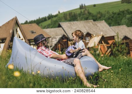 Father And Son Resting On An Air Sofa In The Mountains. Lamzac. Travel, Family Vacation In The Mount