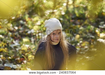 A Girl In Autumn Yellow Leaves In Sunset Rays