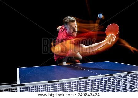 The Table Tennis Player In Motion. Fit Young Sports Man Tennis-player In Play On Black Background Wi