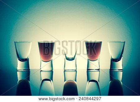 Small Glasses With A Drink Shots Of Alcohol Stainding In A Table With Reflection