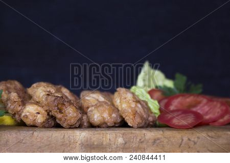 Breaded Chicken Meat With Salad And Lemon Resting On A Rustic Wooden Board