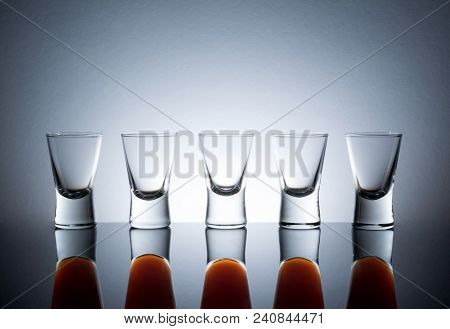 Small Glasses With A Drink Shots Of Alcohol Stainding In A Table With Reflection