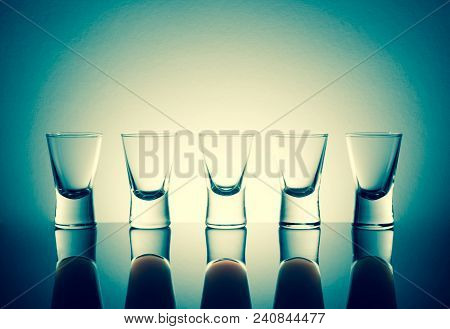 Small Glasses With A Drink Shots Of Alcohol Stainding In A Table With Reflection