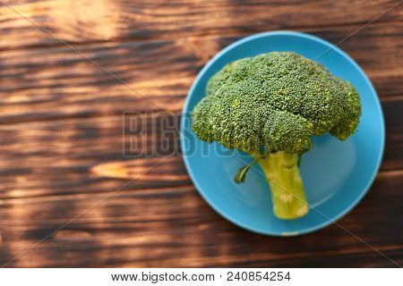 Fresh Brocoli On A Blue Plate On A Wooden Background.