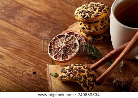 Christmas Concept With A Cup Of Hot Tea, A Large Set Of Cookies On A Homespun Napkin, Cinnamon Stick