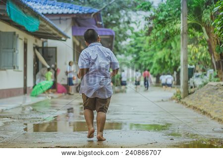 Students Walk To The Flood After Rain In School.