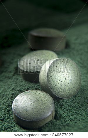 Close Up Of Spirulina Tablets On Powder Background With Low Depth Of Field. Vertical Image.