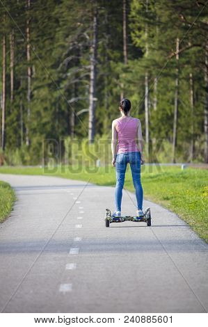Young Woman On Hover Board. Girl Riding Hover Board In Summer Park. Balance Board For Adult.
