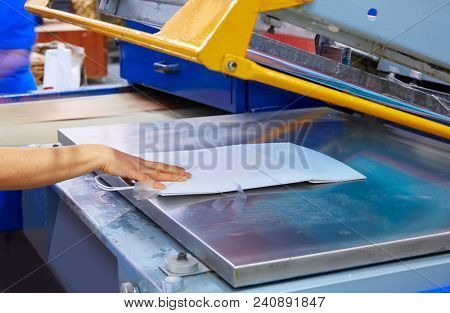 Serigraphy print bags machine in printing factory with operator female hand