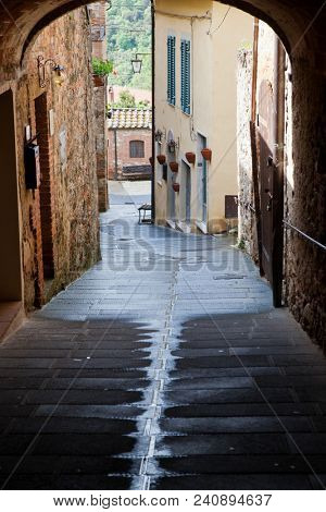 medieval narrow sreet in asciano, Italy