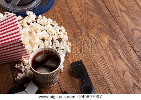 Cinema Background. Clapperboard, Popcorn, Soda Glasses And Film Reel On Wooden Table, Copy Space. Mo