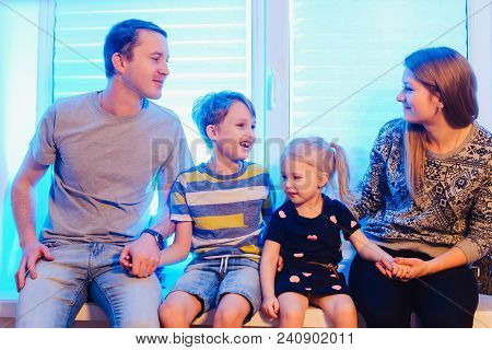 Parents And Kids Sitting Near Window And Having Fun At Home. Smiling A Lot Close Up View