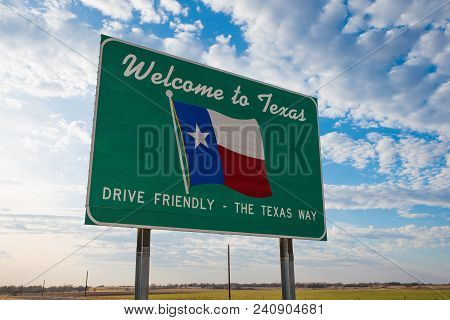 Welcome To Texas Road Sign In Front Of Cloudy Sky