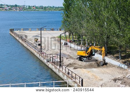 Big Excavator On New Construction Site. Excavator Loader Machine During Earthmoving Works Outdoors A