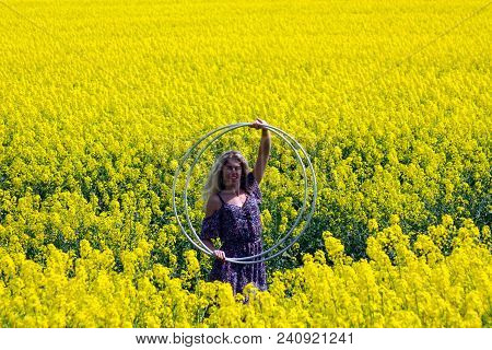 Blonde Girl On The Blooming Yellow Rapeseed Field