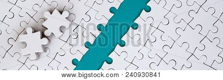 The Blue Path Is Laid On The Platform Of A White Folded Jigsaw Puzzle. The Missing Elements Of The P