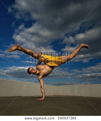 Tricking On Street. Martial Arts. Man Kick With Hand Support Barefoot. Shooted From Bottom Foreshort