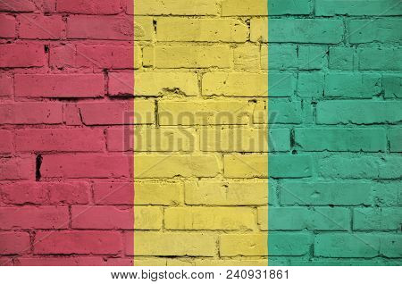 Guinea Flag Is Painted Onto An Old Brick Wall