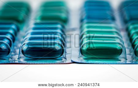 Selective Focus On Blue And Green Soft Gel Capsule Pills In Blister Pack. Naproxen And Ibuprofen (no