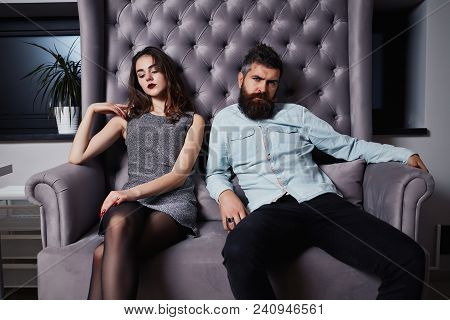 Young Fashion Couple Having Problems Between Each Other. Beautiful Couple Sitting On The Couch And L