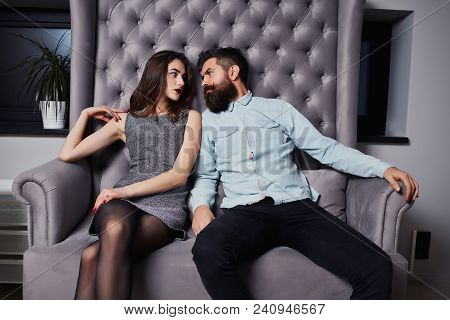 Young Fashion Couple Having Problems Between Each Other. Beautiful Couple Sitting On The Couch And L