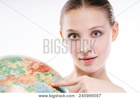 Girl Shows On The Place On The Globe. On A White Background