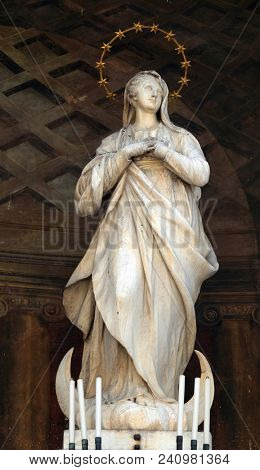 MODENA, ITALY - JUNE 04: Virgin Mary statue on Clock tower, Modena town Hall on Piazza Grande, UNESCO world heritage site, Modena, Italy on June 04, 2017.