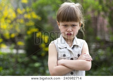 Pretty Funny Moody Little Blond Preschool Girl In White Sleeveless Dress Looks Into Camera Feeling A