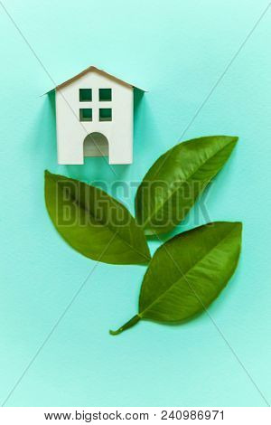 Miniature Toy Model House With Green Leaves On Blue Pastel Colourful Trendy Backgdrop. Eco Village, 
