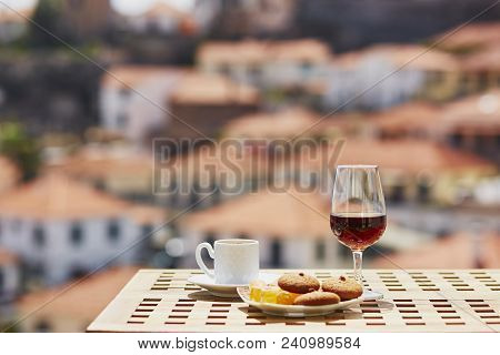 Two Glasses Of Madeira Wine And Two Cups Of Fresh Espresso Coffee In Street Cafe With View To Funcha