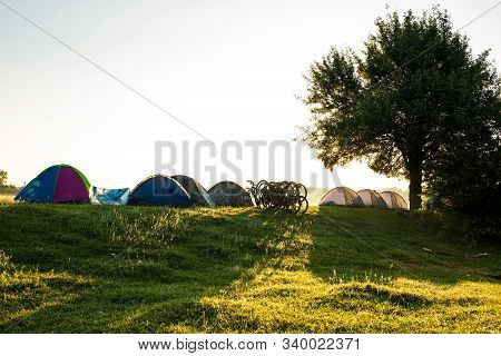 Morning On A  Camp With Tents And Bycicles, On A Wild Meadow