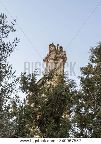 Jerusalem, Israel, December 07, 2019 : Statue Of The Mother Of God With A Baby In Her Arms On The Ro