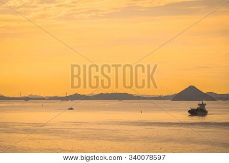 Boat Ferry Is Travel Along Takamatsu Islands In Japan, With Golden Sunset Reflection Sky For Vacatio