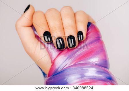 Hands With Black Manicure Holding Slime In Blue And Pink Vibrant Colors