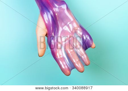 Hands With Holding Slime In Purple Color On Blue Background