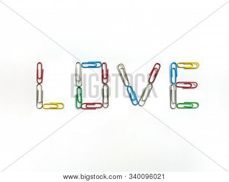 Color Paperclips Arranged To Love Word On White Background