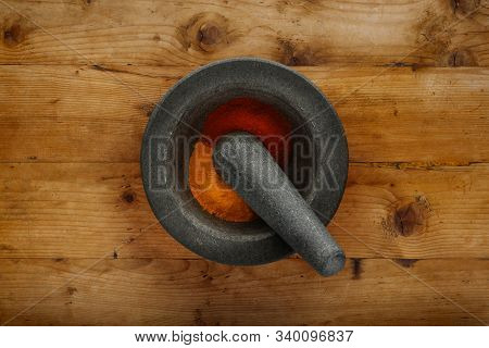 Plan View Of Pestle & Morter And Ground Spices, Shot On A Wooden Background, With Space For Copy