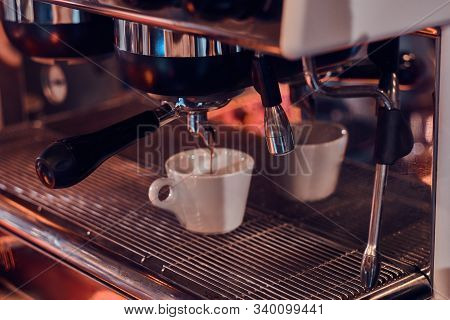 Process Of Coffee Making, Coffe Machine Is Pourig Fresh Coffee To The White Cup.